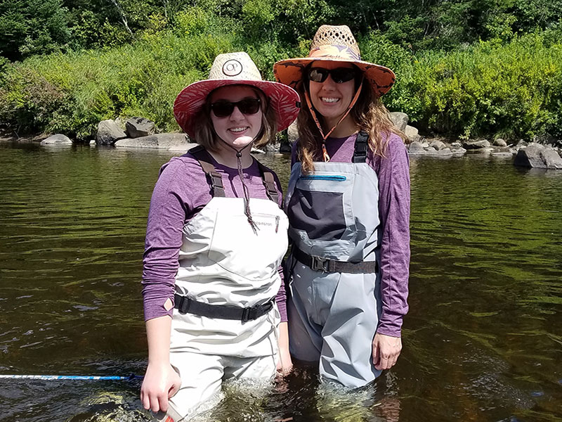 Two Smiling Women Standing in Adirondack River